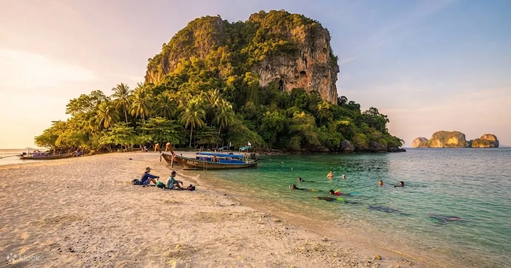 Swimmers and longtail boats on the palm-fringed sand spit of Poda Island, Krabi